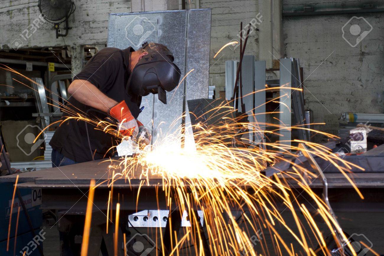 9313119-sparks-frying-over-the-working-table-during-metal-grinding-Stock-Photo.jpg